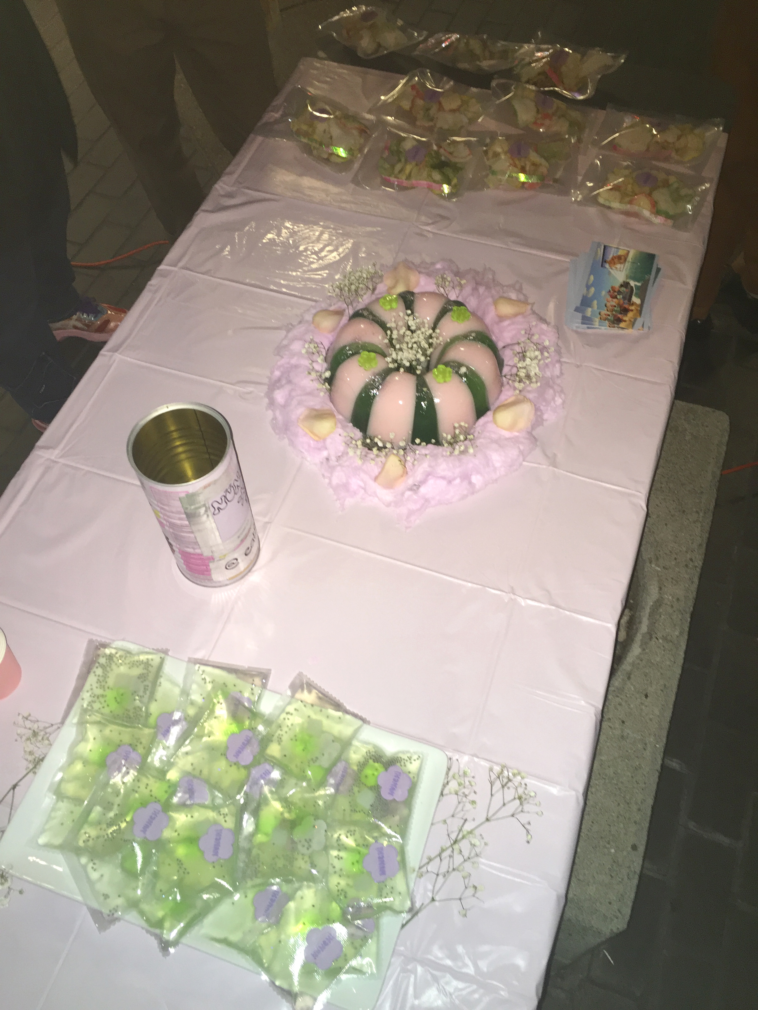 A pink table with jello cake and snacks on it